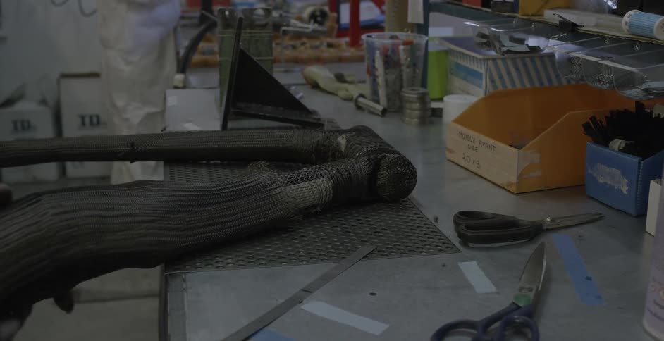 A worker wraps fabric around a pipe