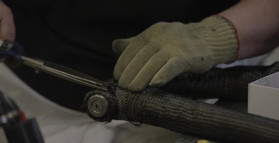 A person is cutting thread off a tool
