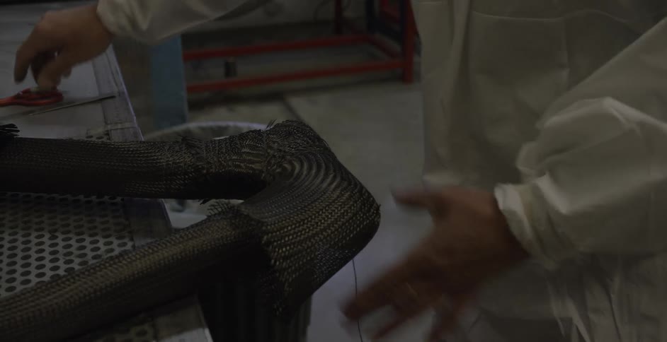 A person is wrapping thread around an object