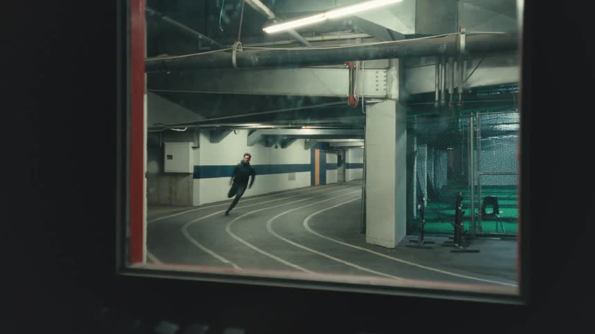 Young man doing a strong sprint running on an indoor track