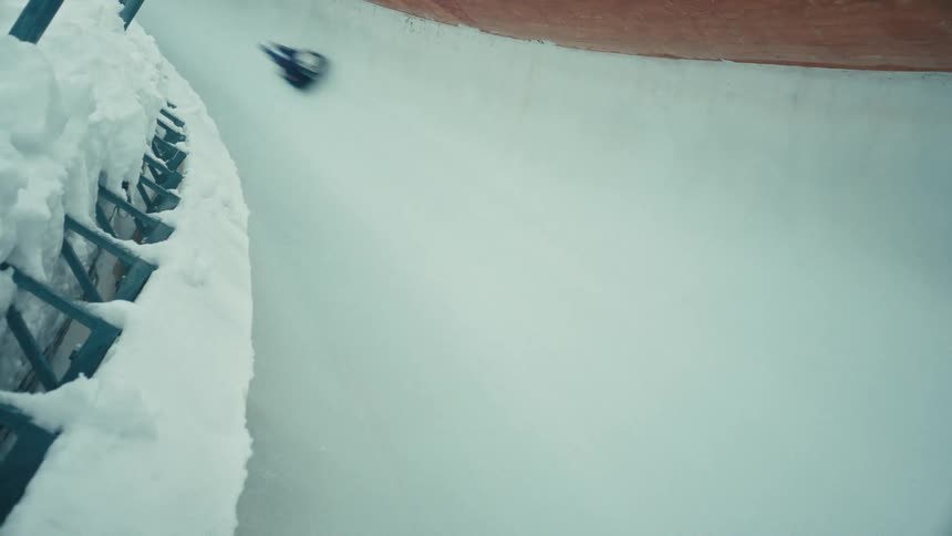 A skeleton racer sliding down an icy track at high speed