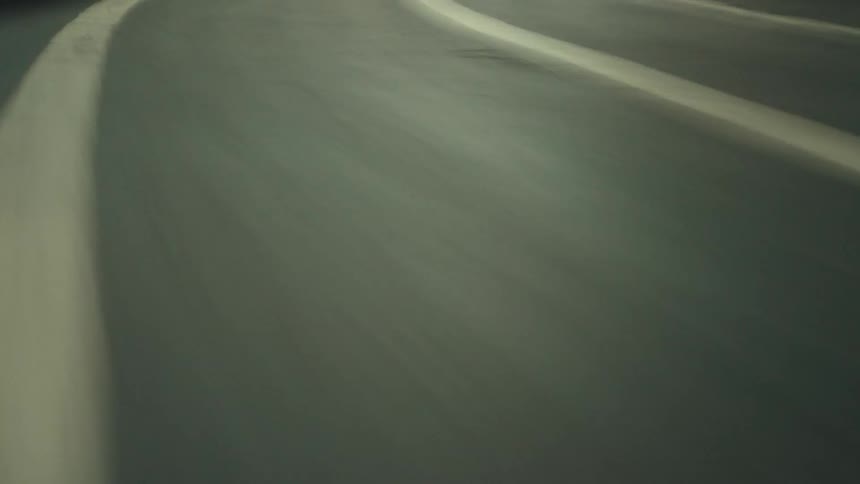 Roadway winds through a brightly lit tunnel