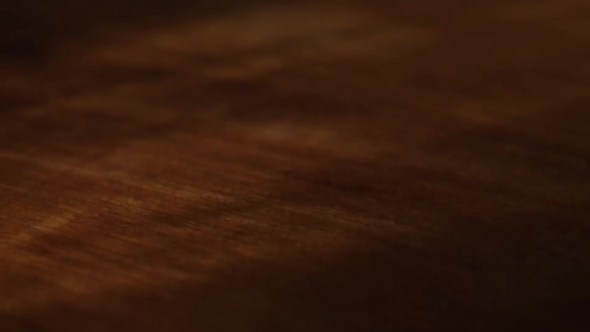 Streams of light likely from a window are flashing chaotically onto a wooden table