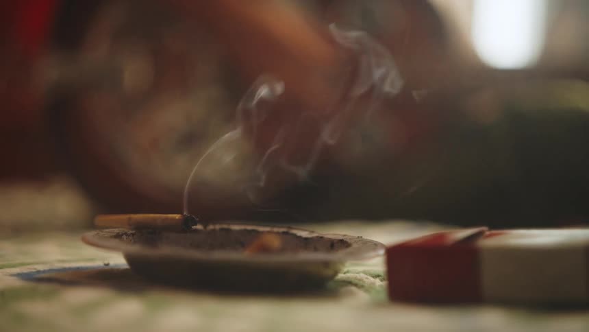 Setting a joint on the edge of an ashtray after taking a hit