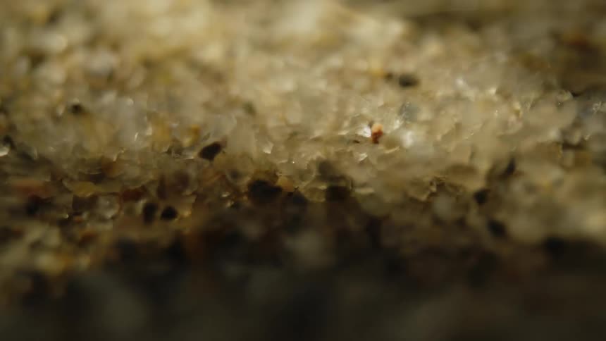 Extreme close up underwater with moving sand and boulders