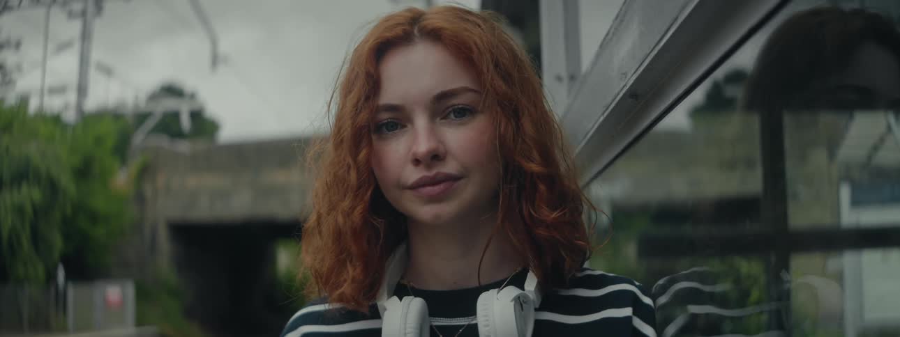 A close up footage of a lady standing outdoor beside a glass window