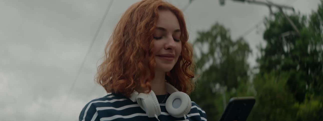 Woman looking down at a smartphone