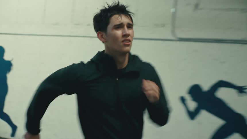 Man running with facial expression of effort and determination in an indoor space