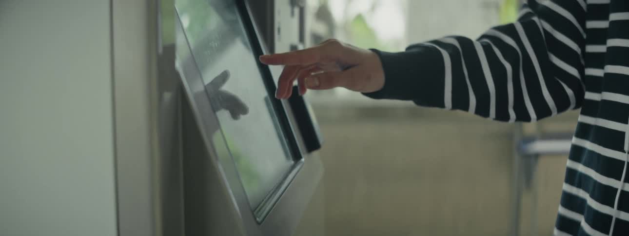 A clip of a persons hand operating a cash machine