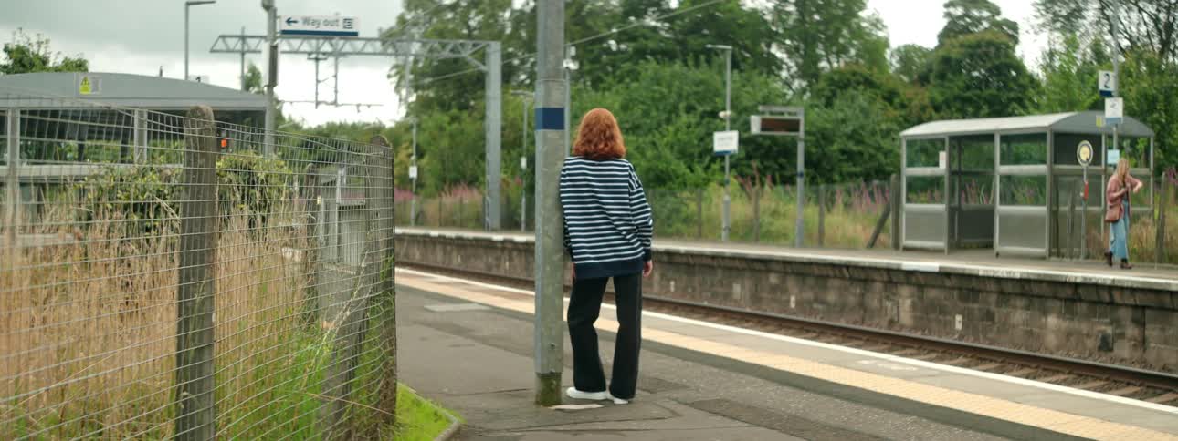 Two women in an outdoor subway station during the day