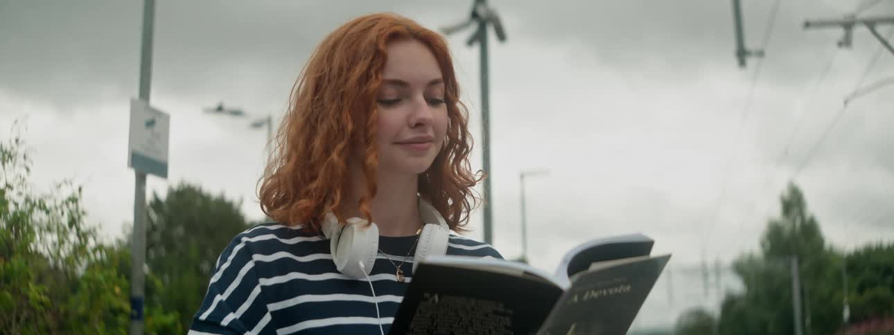 A woman is reading a book outside