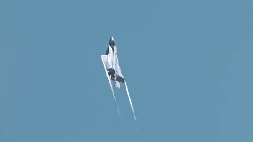 A jet flying upwards into a sky that is completely blue