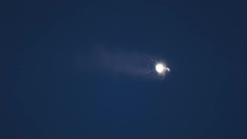 View of blue sky with rocket going up