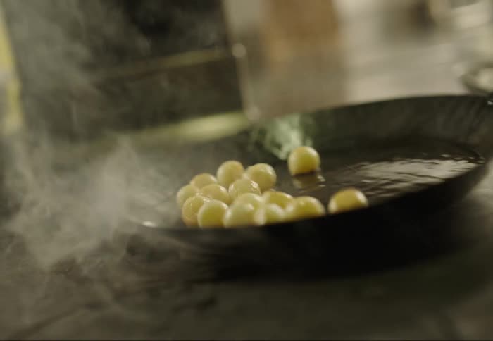 Smoke rising as a person cooks food in a pan