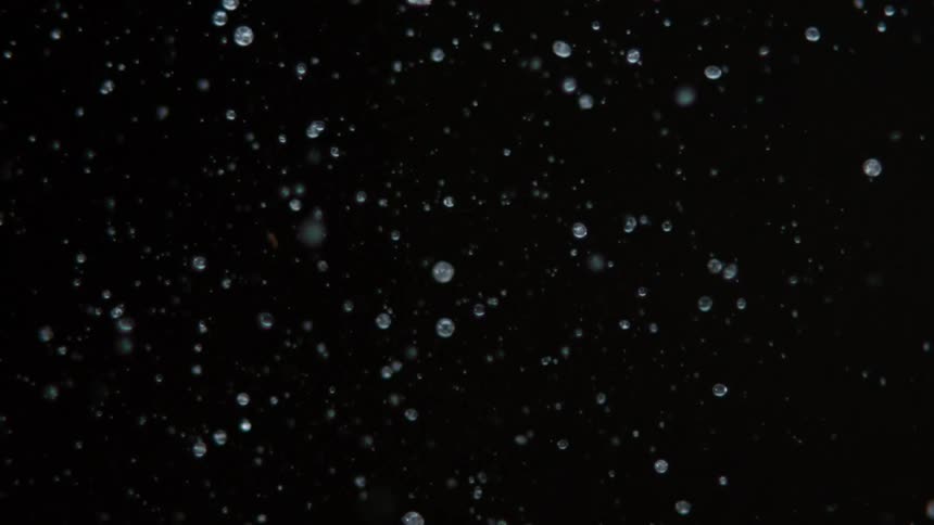 Fruits flying against a dark background with water droplets