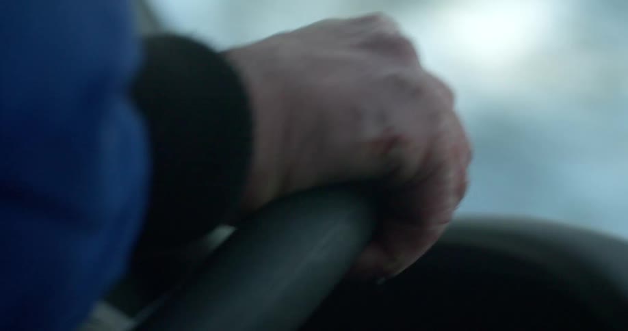 A person switches hands on the steering wheel while driving