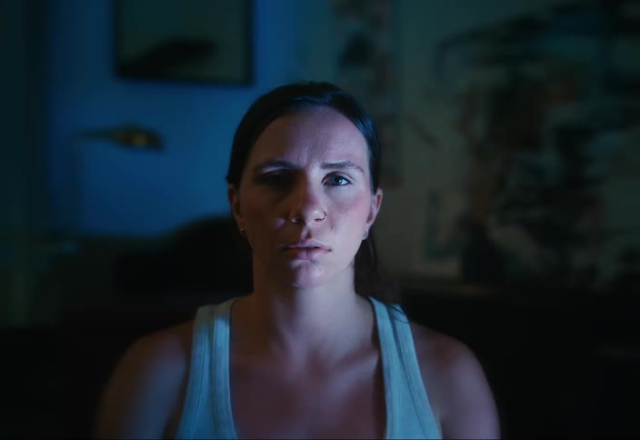 Woman sitting focused in a dark room with lights