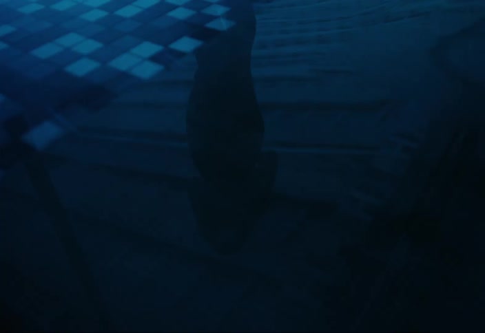 Legs of a person walking towards a swimming pool