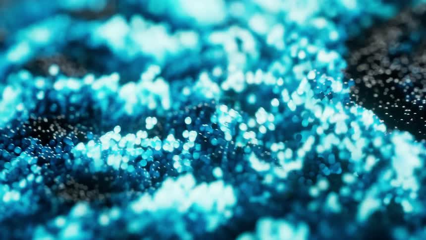 Tiny iridescent beads pulse and glow hue of blue as the light pulsates beneath them illuminating their dance