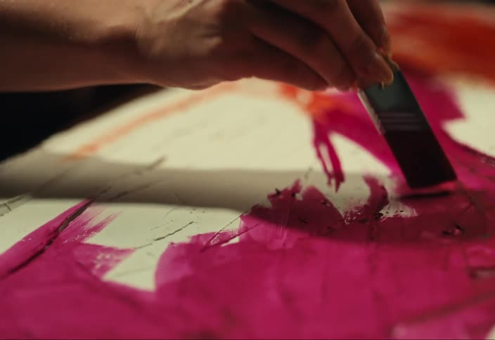 Woman with paintbrush painting a picture