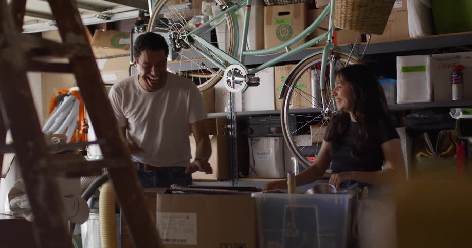Couple having fun inside a garage with boxes