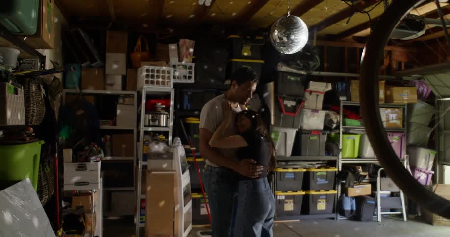 Couple in a garage with boxes dancing together