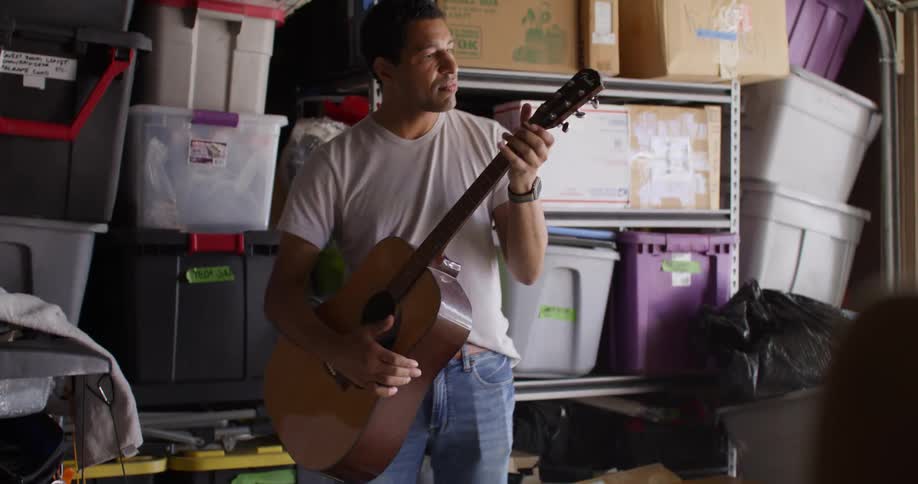 Man picking up a guitar and playing