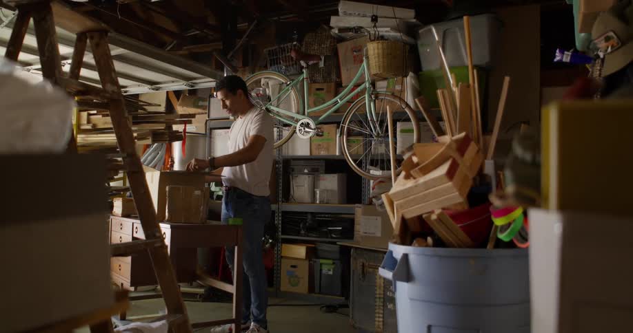Man indoors opening a box
