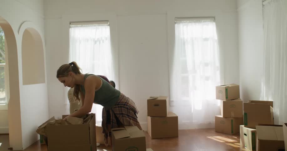 Two people are unpacking boxes