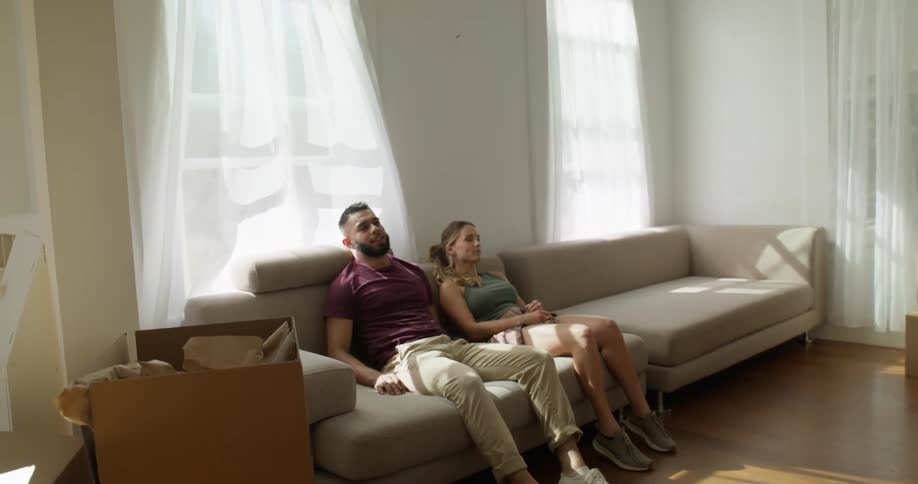 A man and woman sit on the couch