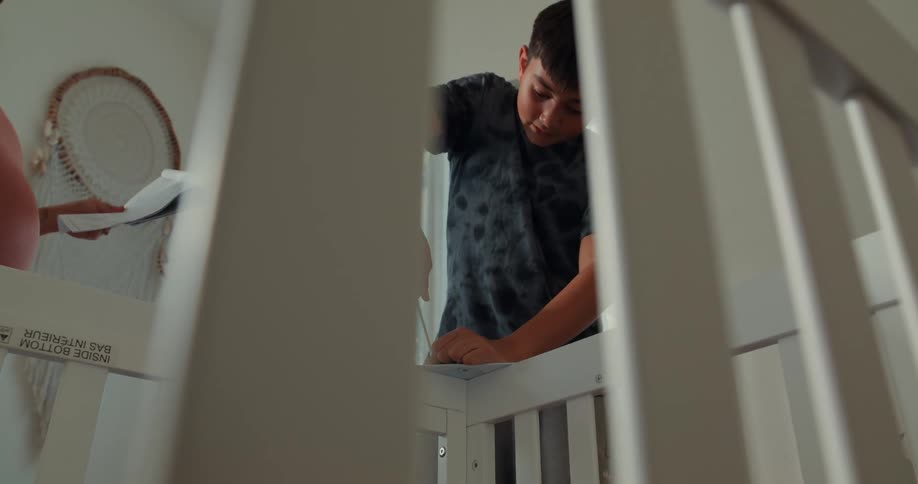 Boy with a tool assembling a crib