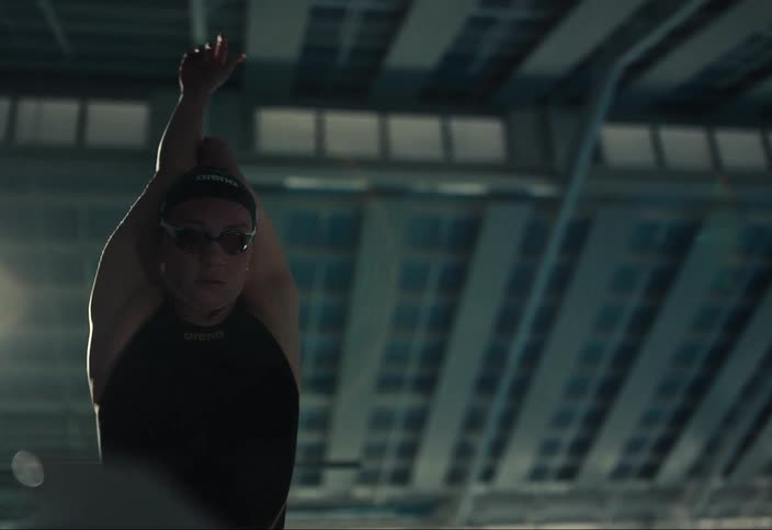 A swimmer stretches before going in the pool