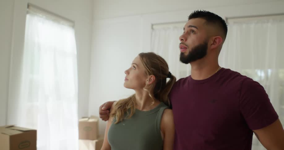 Happy couple inside a room with several moving boxes