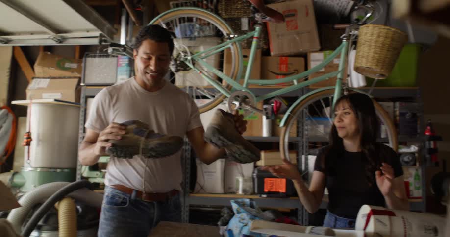 Woman handing boots to a man who puts them inside a box