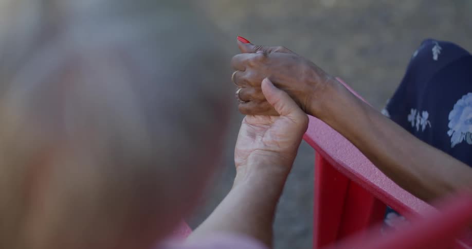 Close up of two peoples hands with their hands clasped together