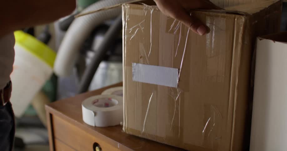 A man puts a label on a box