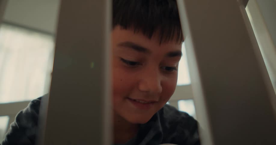 Boy assembles a crib in a room