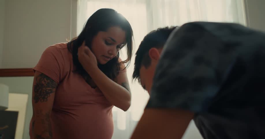 A mother watches her son work on something