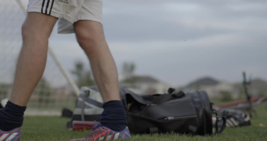 A soccer player walks on a soccer field