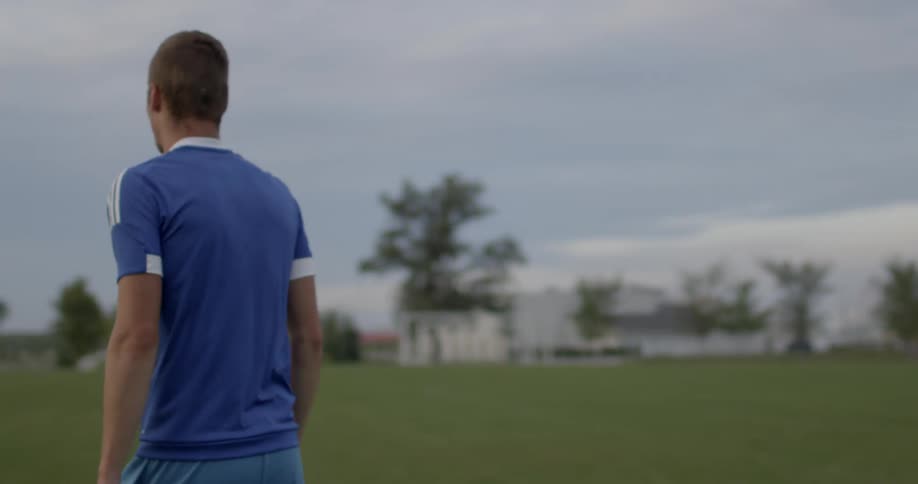 A soccer player walks on a soccer field