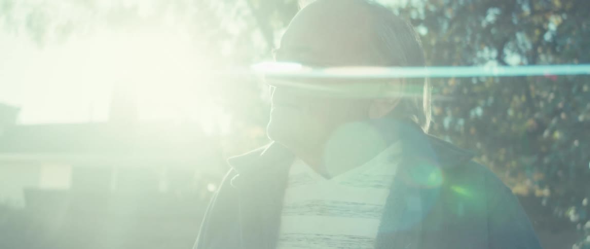 An elderly man walking on the backyard on a sunny morning