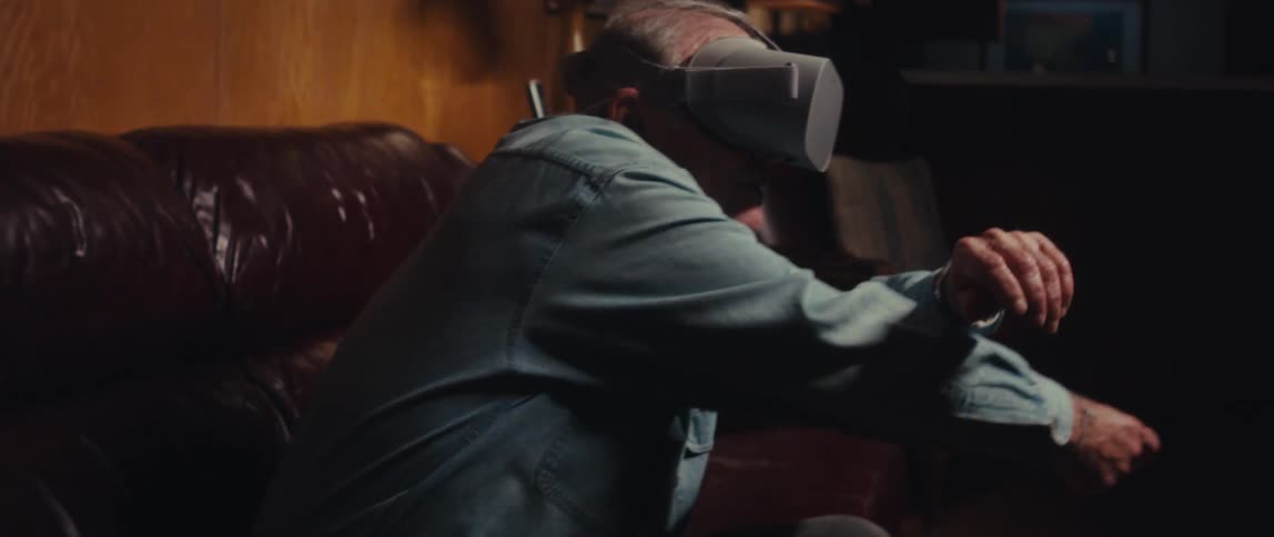 Elderly man sitting playing with vr headset