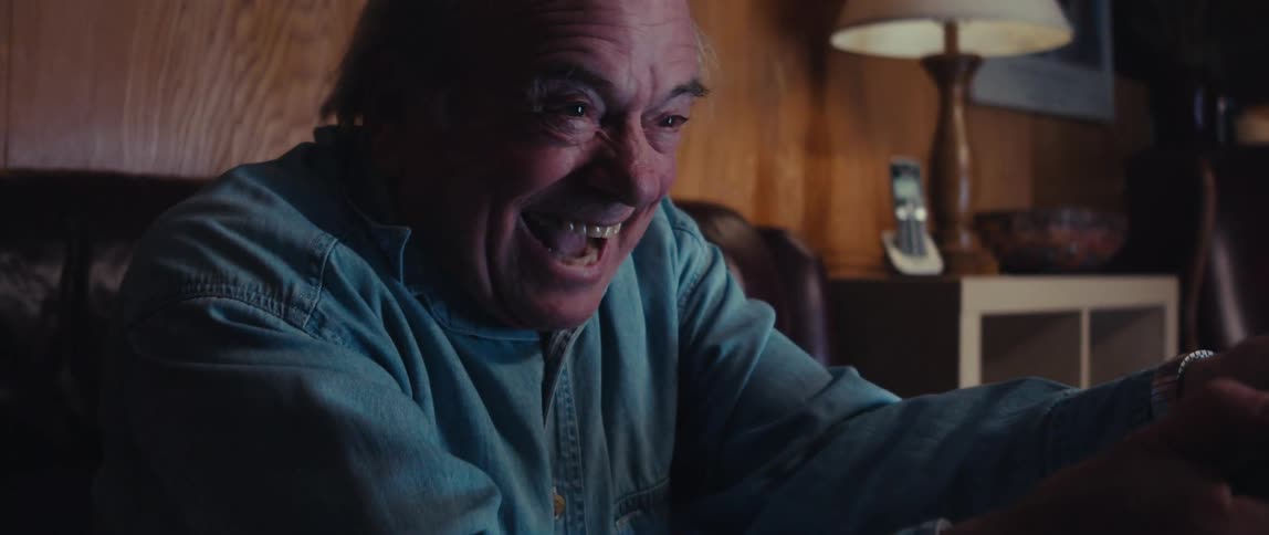 Elderly man sitting having fun while controlling and playing video games