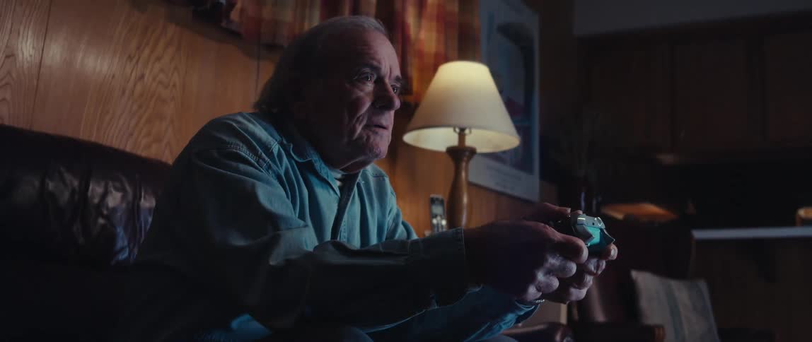 Elderly man playing video game with wireless remote control