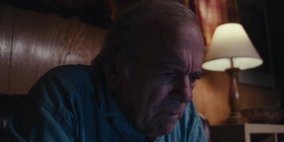 A man leans forward examining something