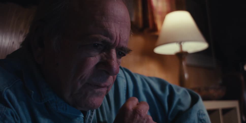 Elderly man sitting in a dark room