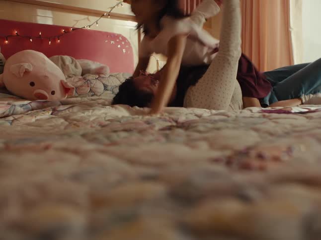 Sisters play around on the bed