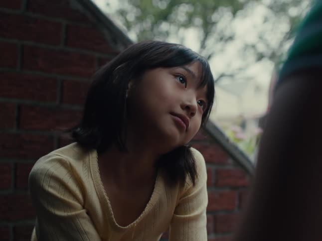 Portrait of a little girl sitting next to another person