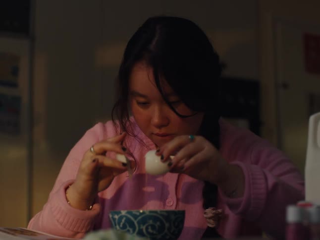 Girl cracking an egg into a bowl and beating it with a spoon