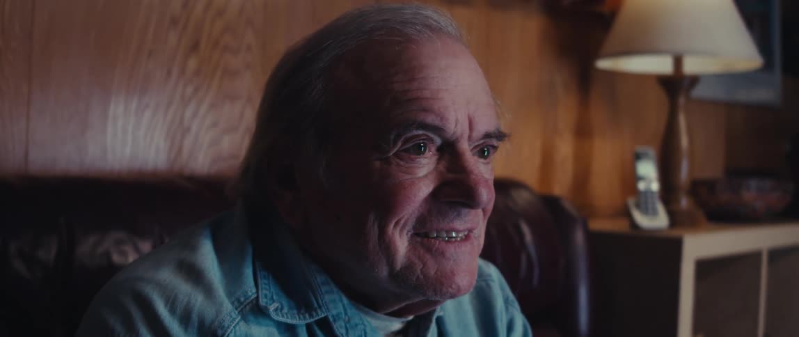 Elderly man playing video game with wireless controller and having fun